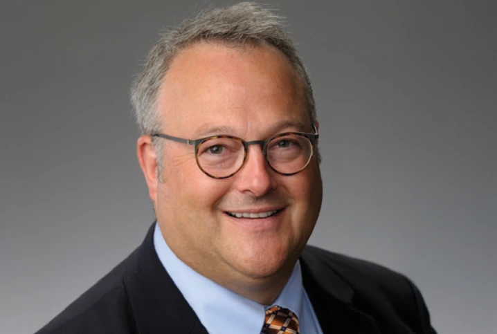 Author Stuart C. King, MD, MBA, smiling in a suit and glasses.